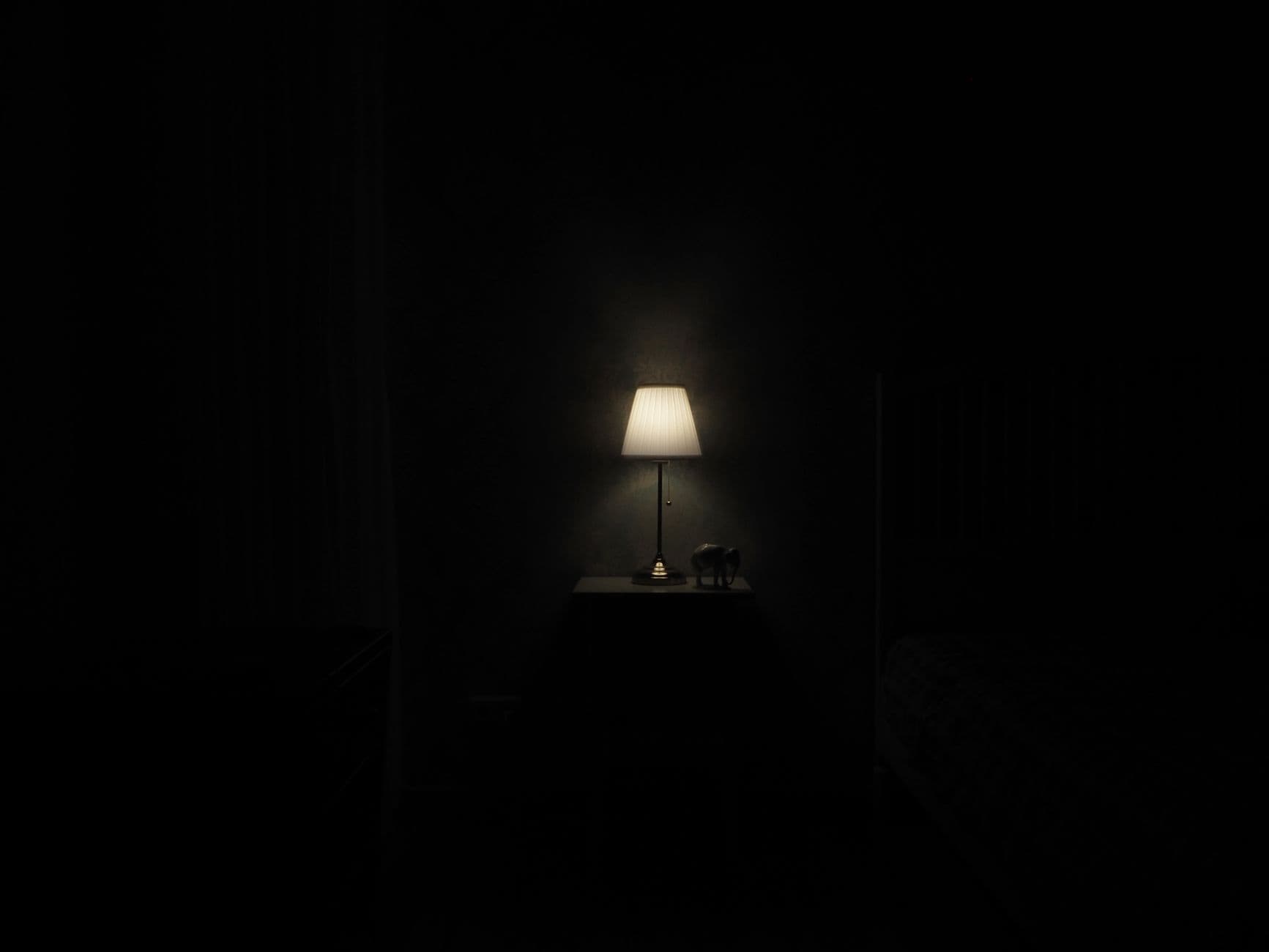 A phone lighting up and ringing in a dark bedroom