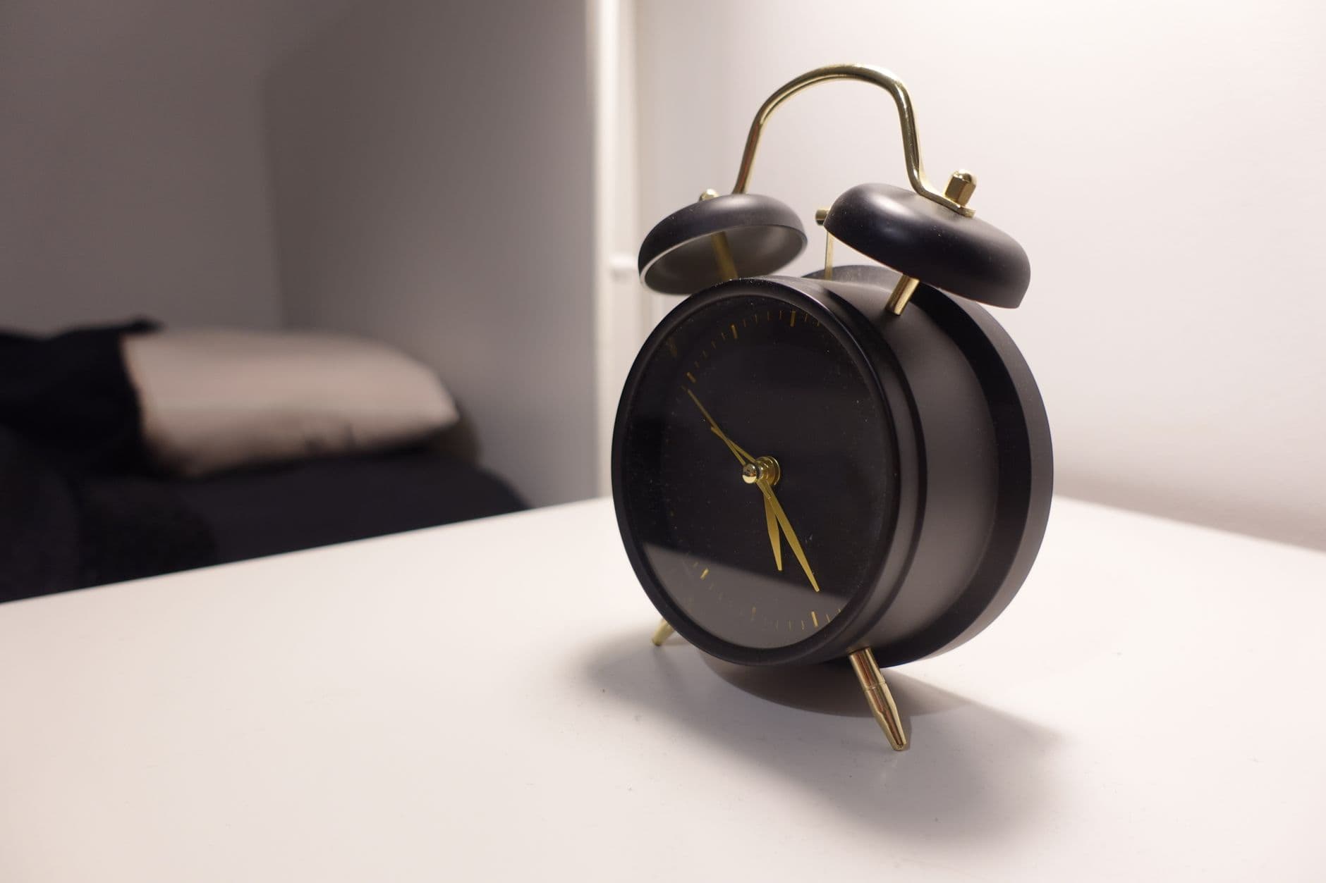 A smartphone alarm clock on a bedside table