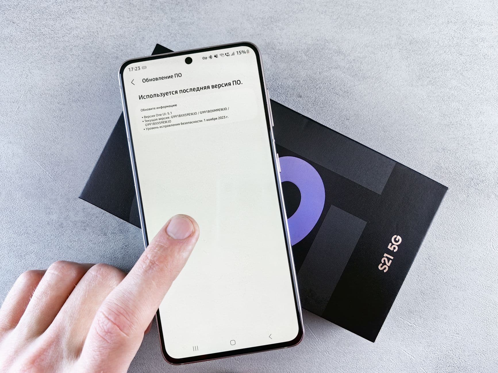 A hand photographing a medicine box with a smartphone