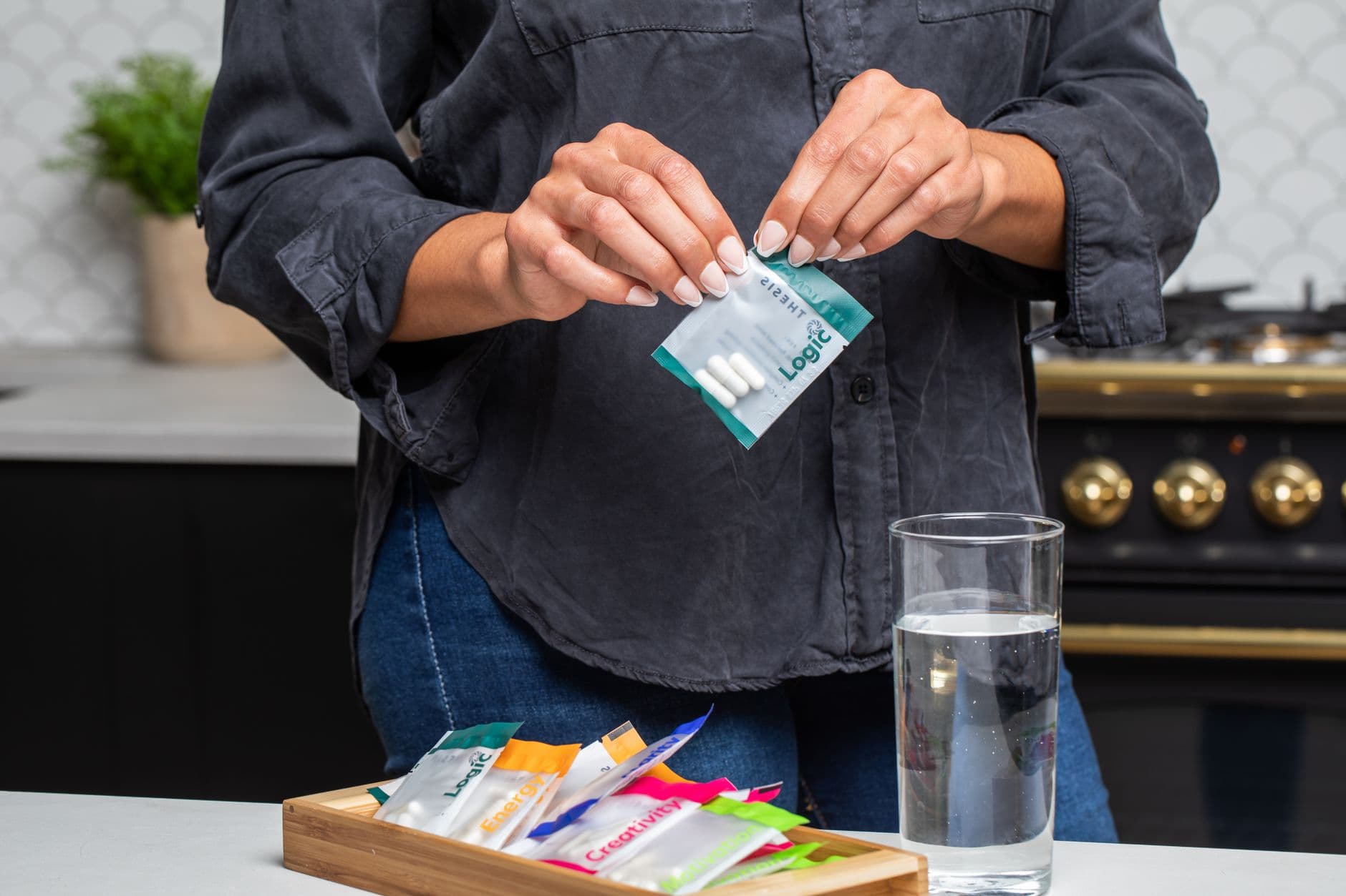A pill organiser and a glass of water on a kitchen counter