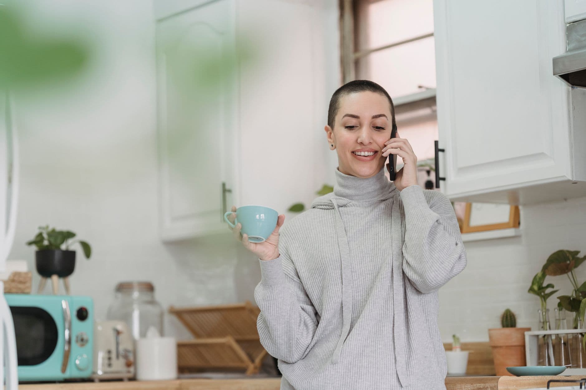 Someone answering a ringing mobile phone in a kitchen