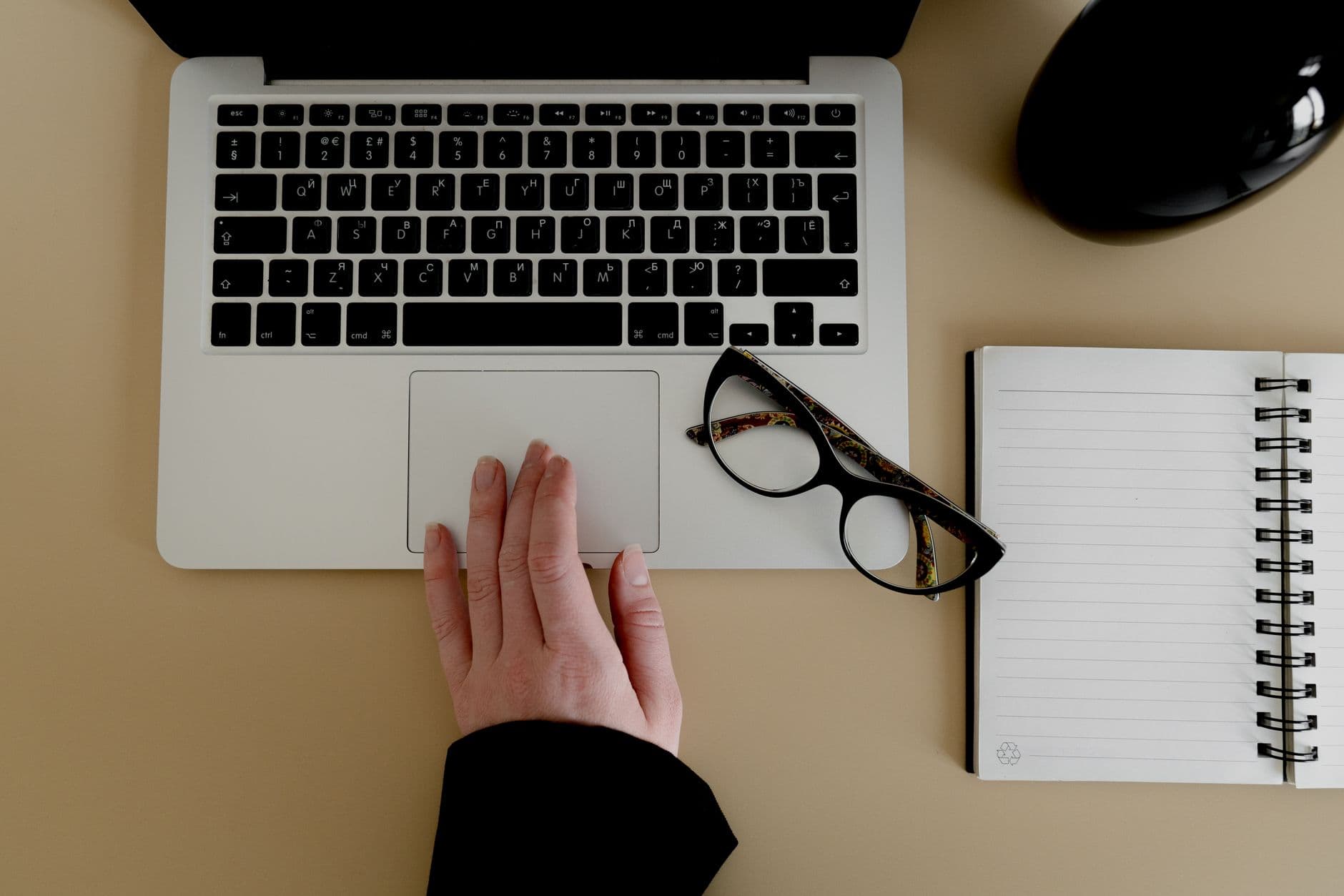 A hand using a laptop trackpad in an office