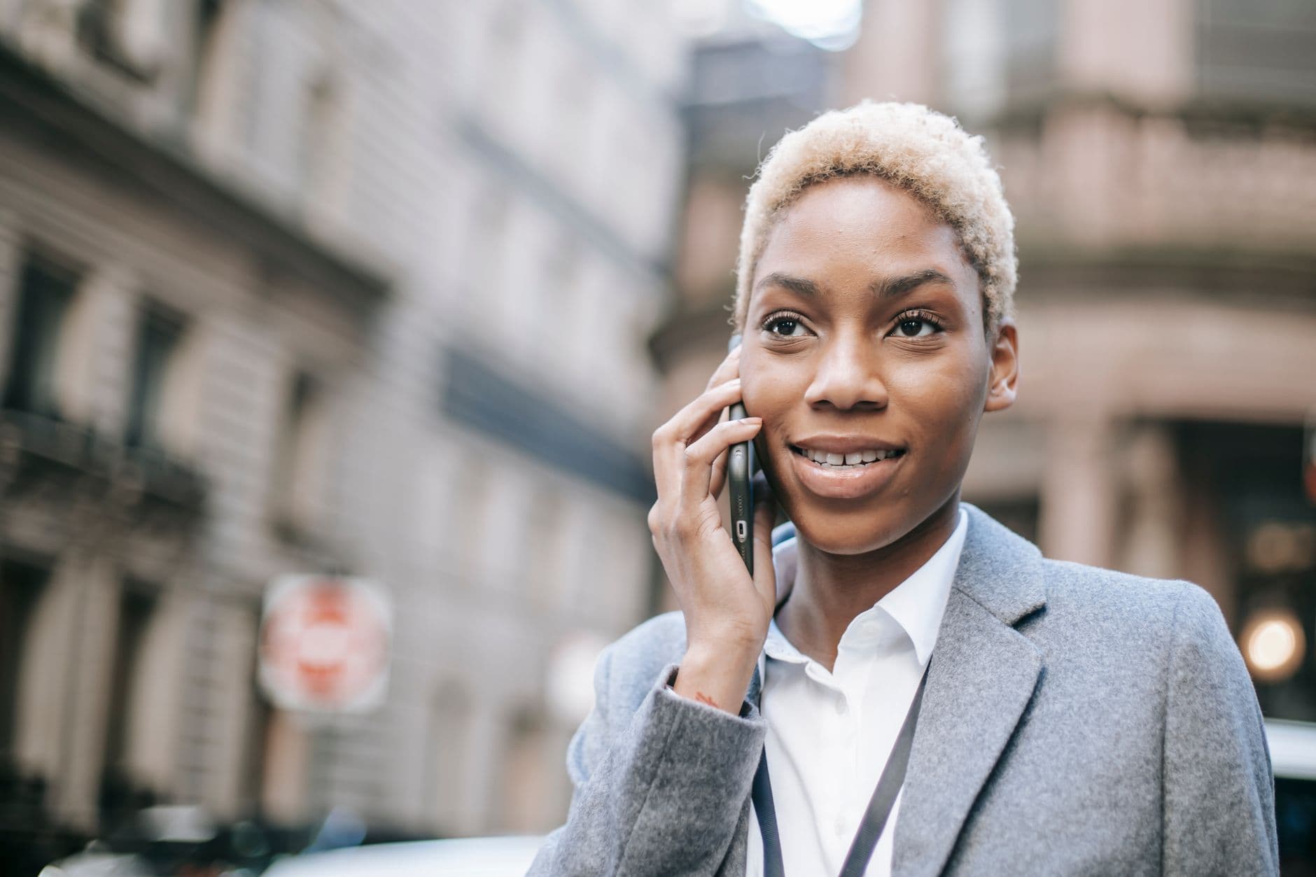 Someone speaking into a smartphone outdoors