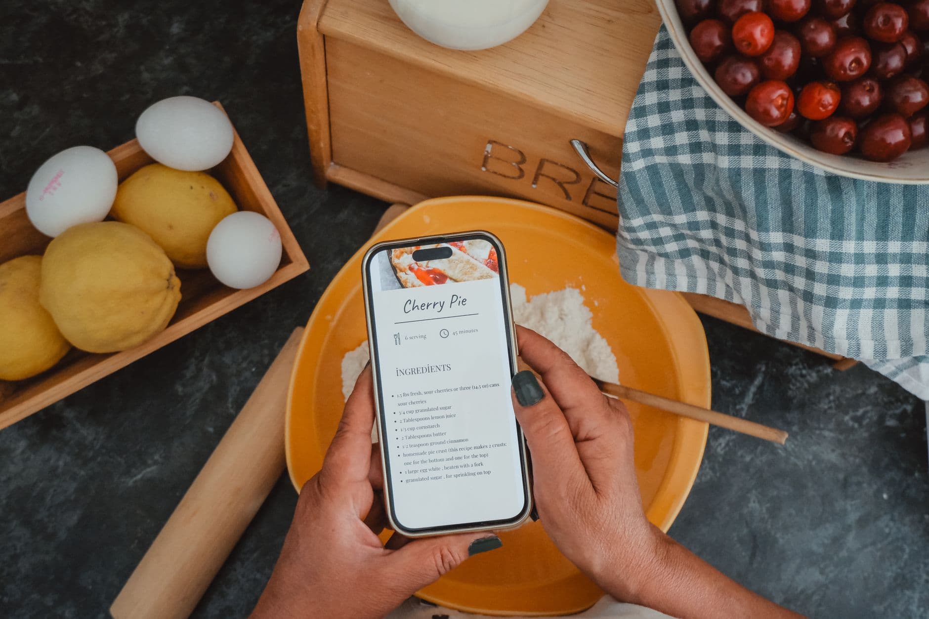A parent glancing at their phone while cooking