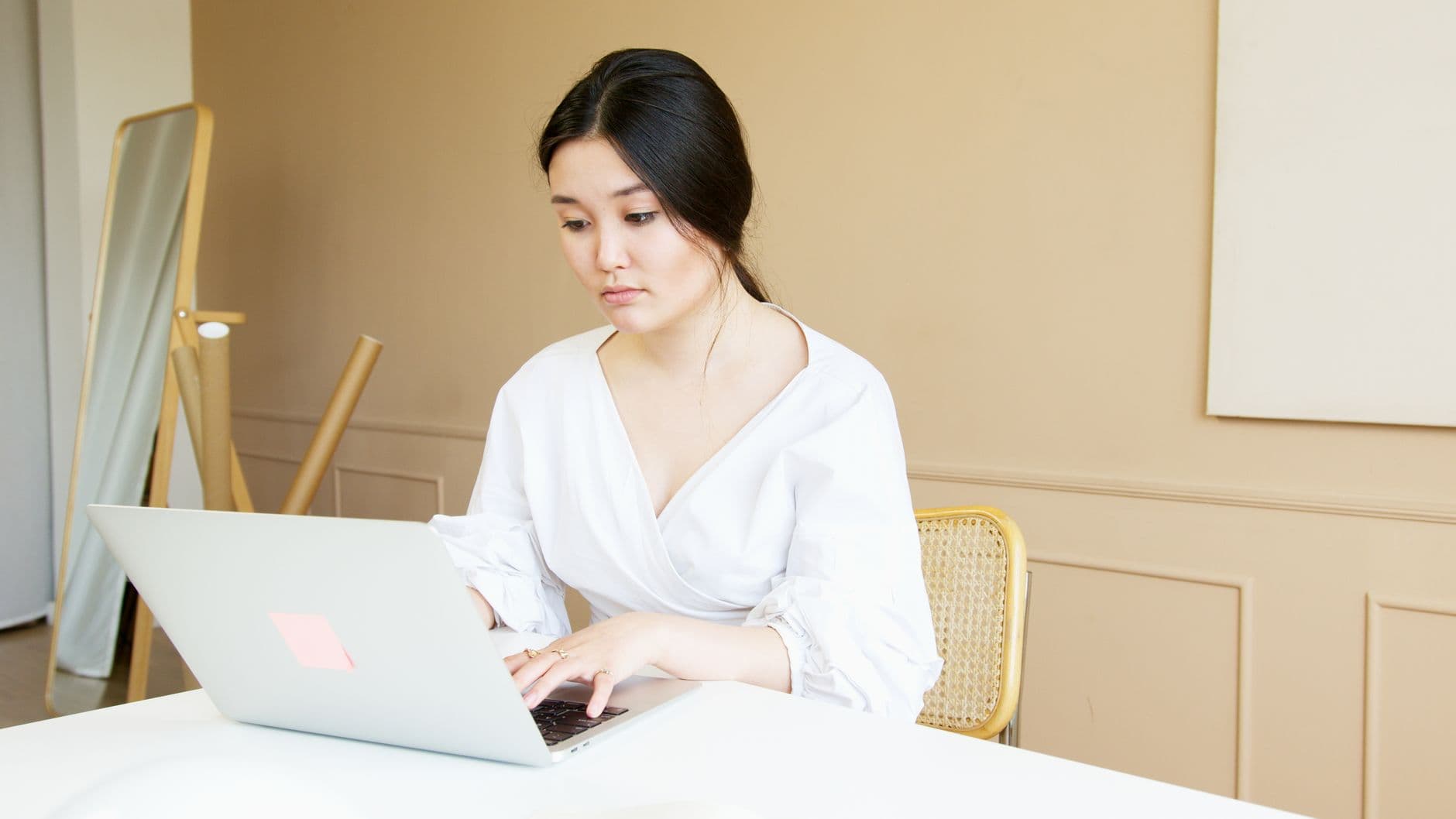 A man typing on a laptop at a clean desk
