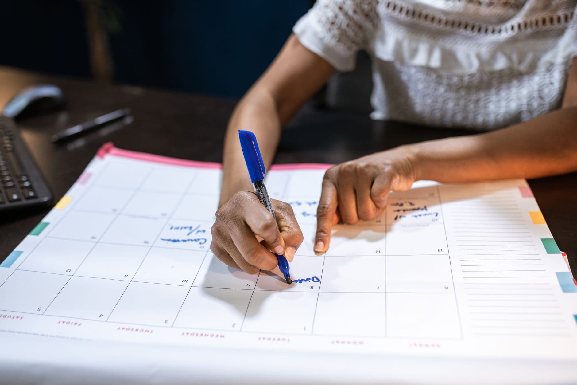 A wall calendar with days marked in colored pen