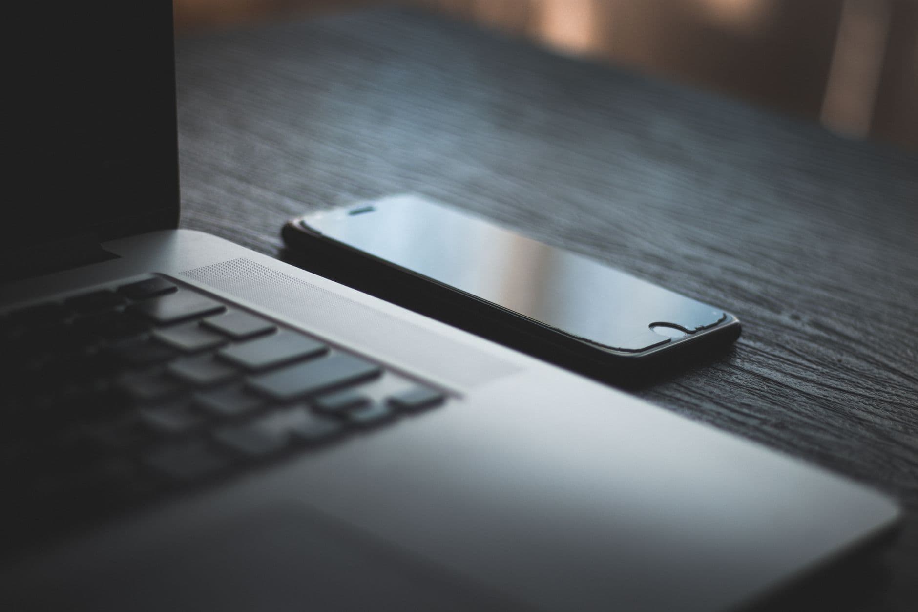 A laptop and a phone on the same desk