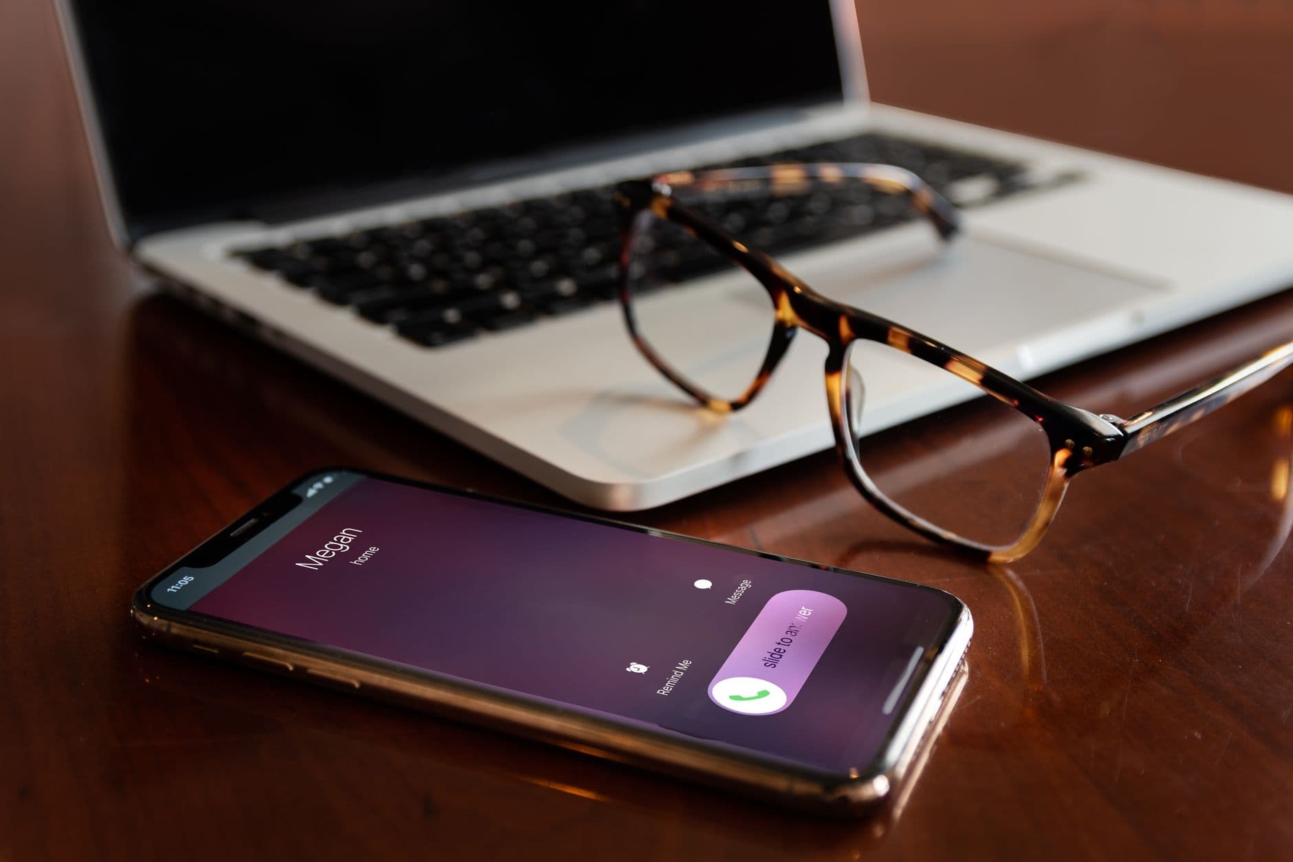 An iPhone lying on a table with a call screen lit up